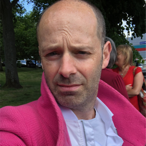 Simon with serious look and pink jacket